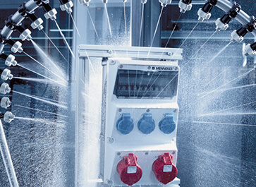 Комбинация розеток AMAXX® компании МЕННЕКЕС распыляется в испытательной лаборатории водой.